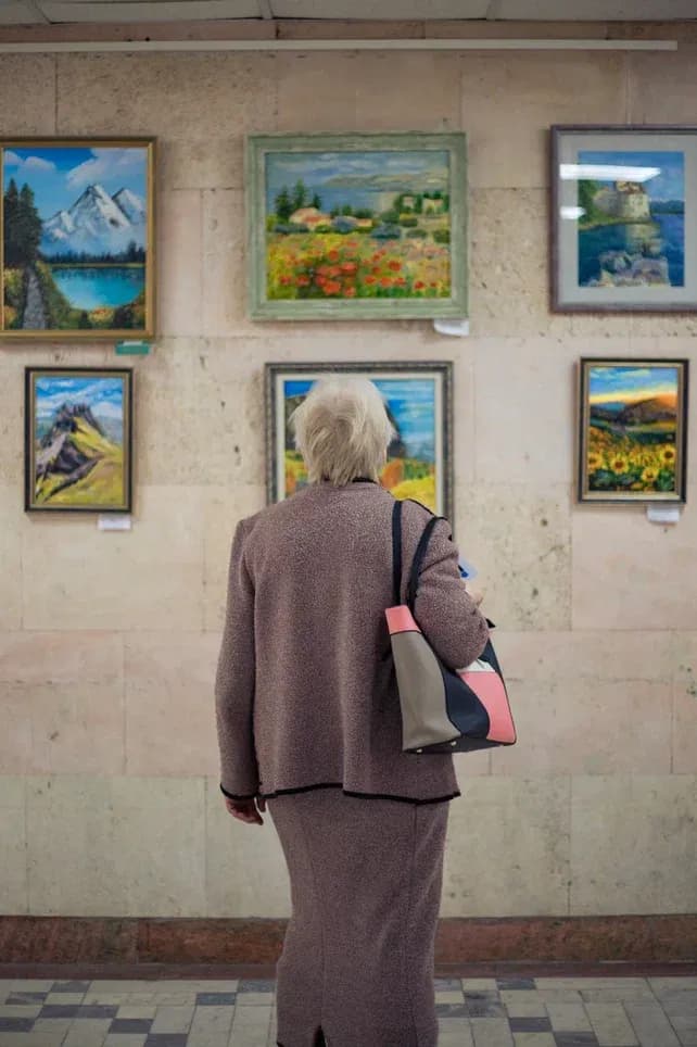 Бабушка разглядывает картины